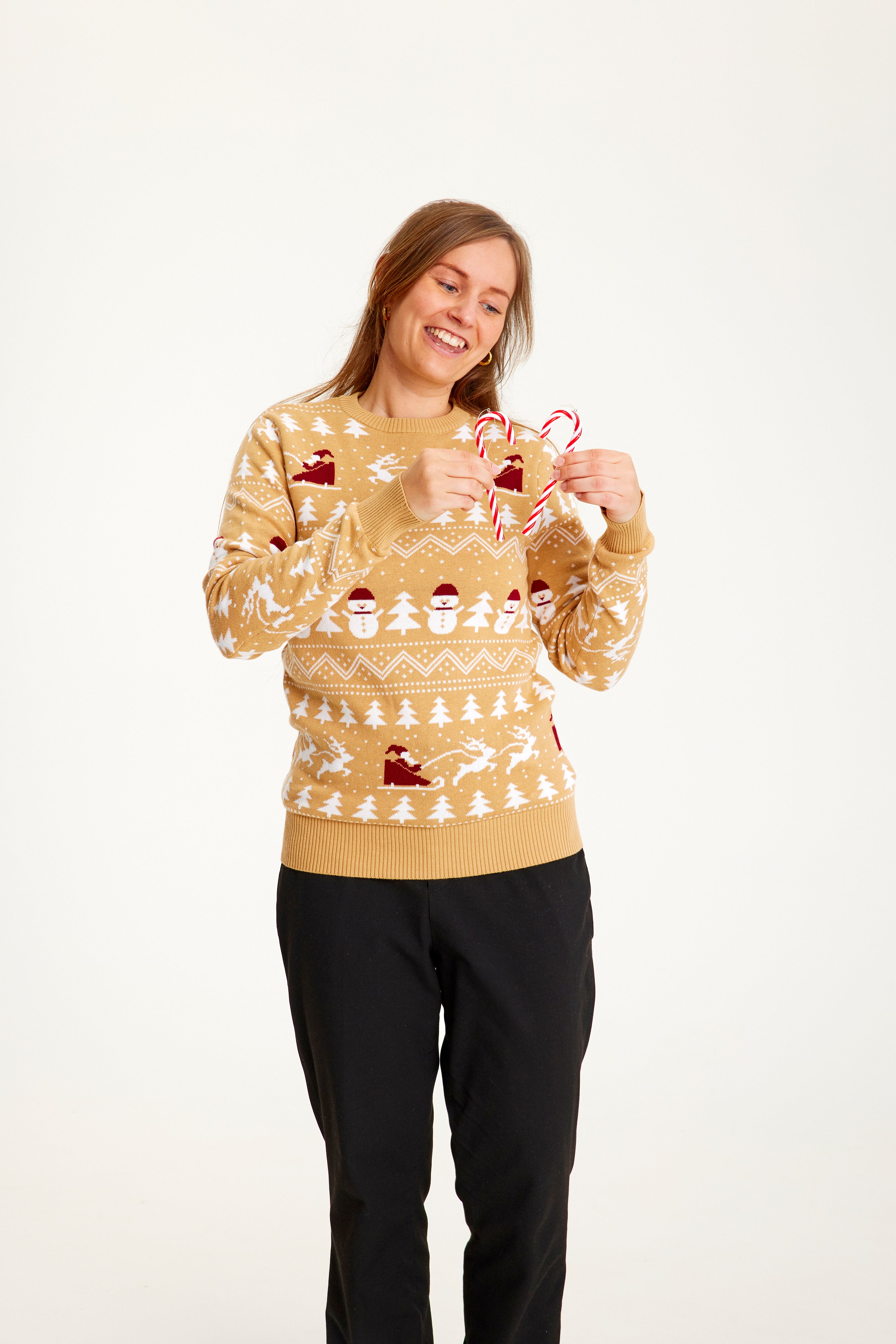 Une femme portant un pull de Noël beige.